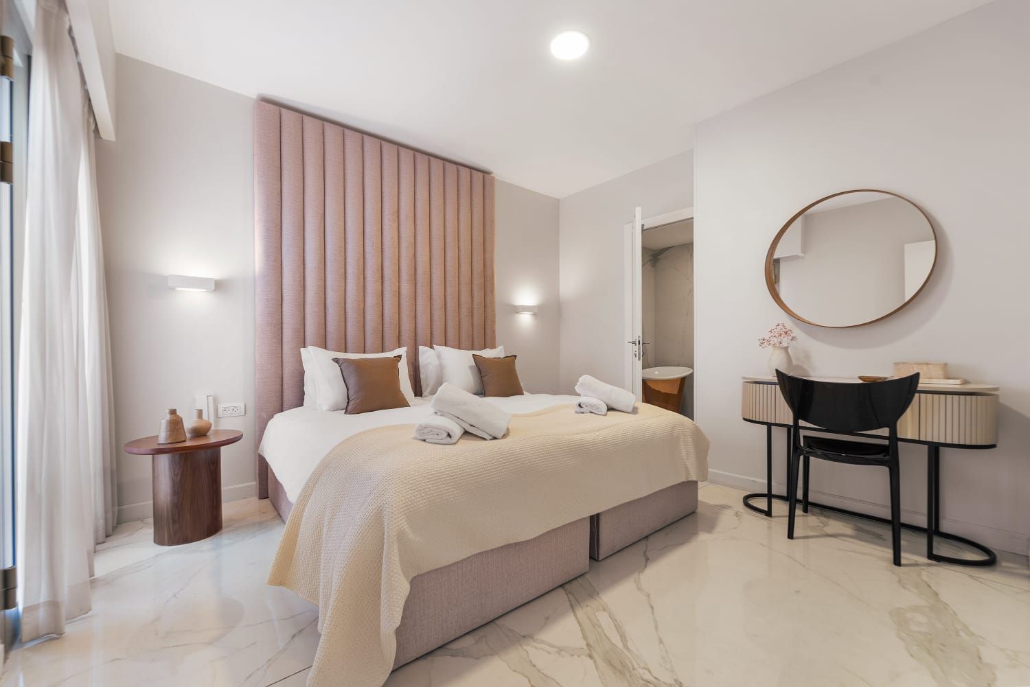 A bedroom with a kosher bed , desk and mirror.