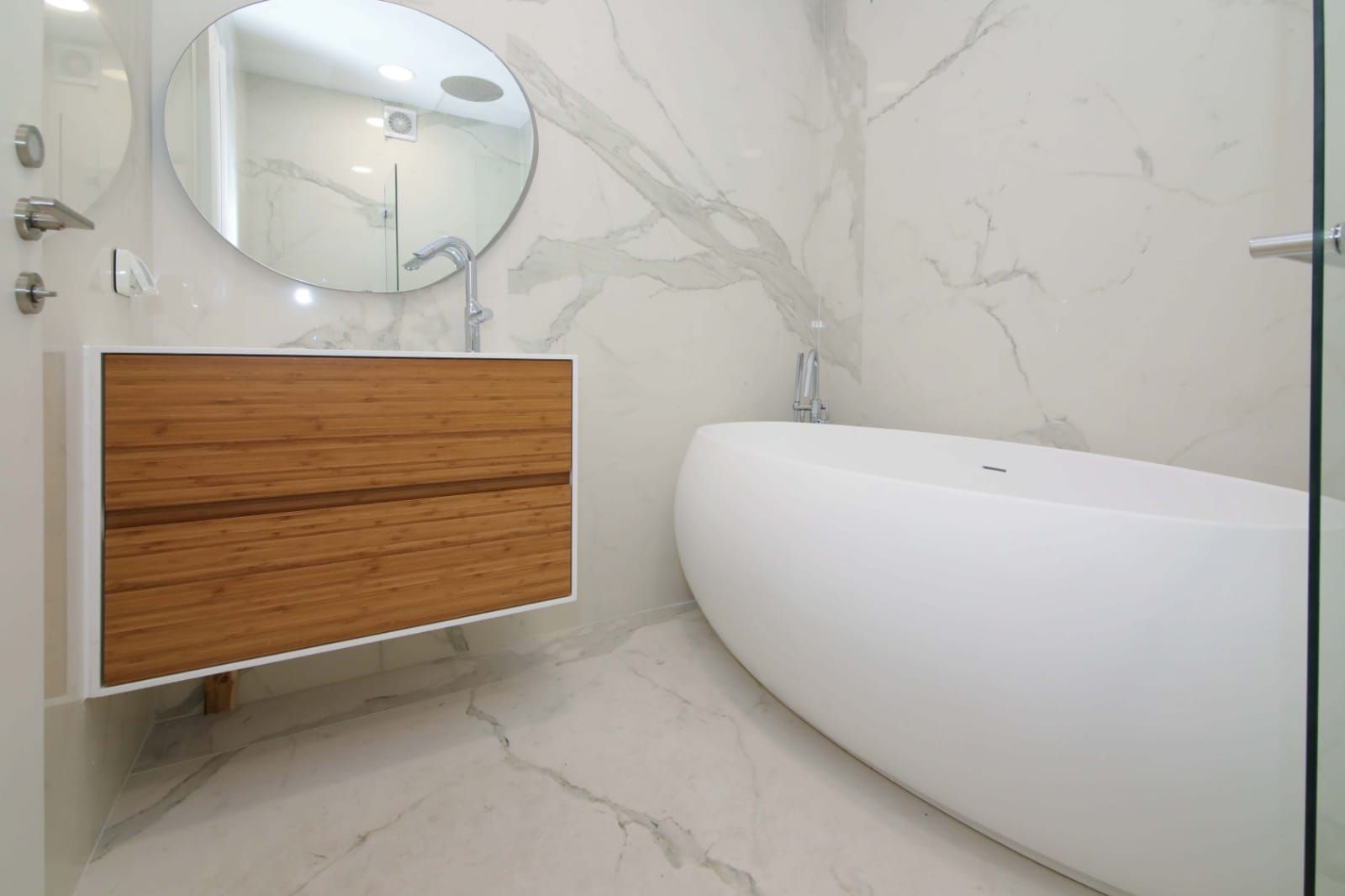 A bathroom with a bathtub , sink and mirror.