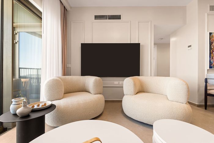 A living room with two chairs and a flat screen tv