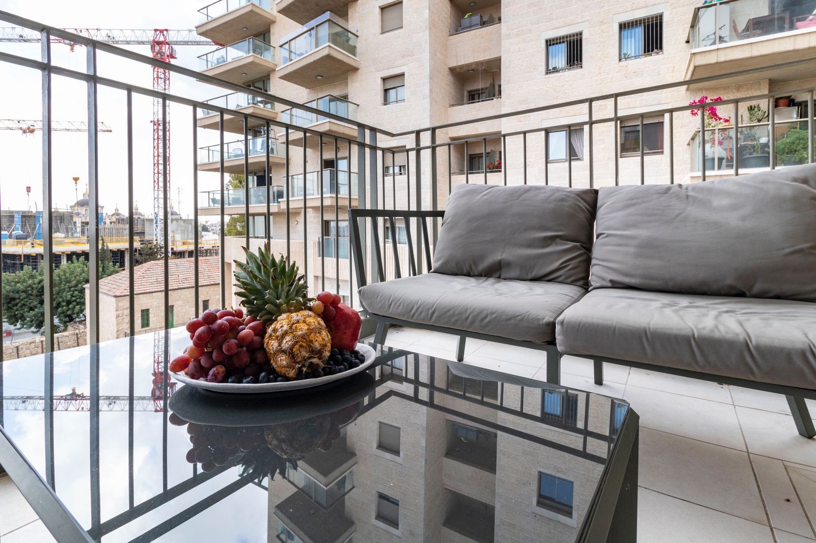 A balcony with a couch and a table with fruit on it.