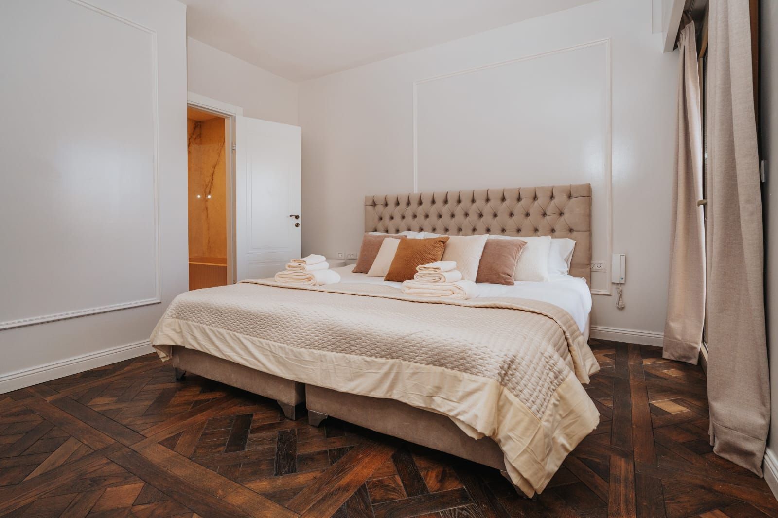 A bedroom with a king size kosher bed and a wooden floor.