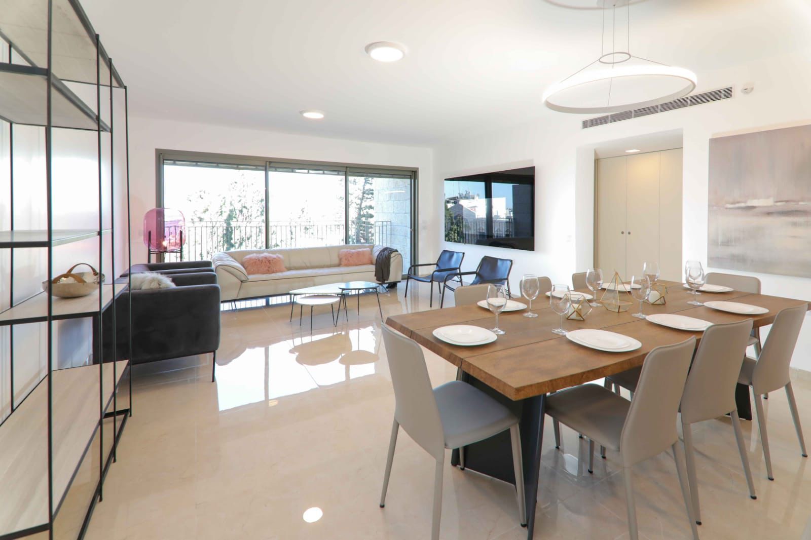 A living room with a dining table and chairs and a couch. kosher apartment in Jerusalem