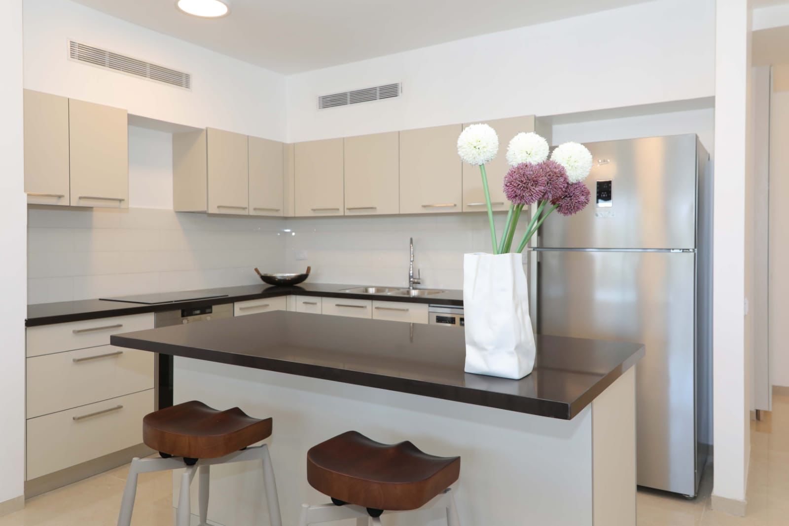 kosher kitchen with a big refrigerator and a vase of flowers on the counter