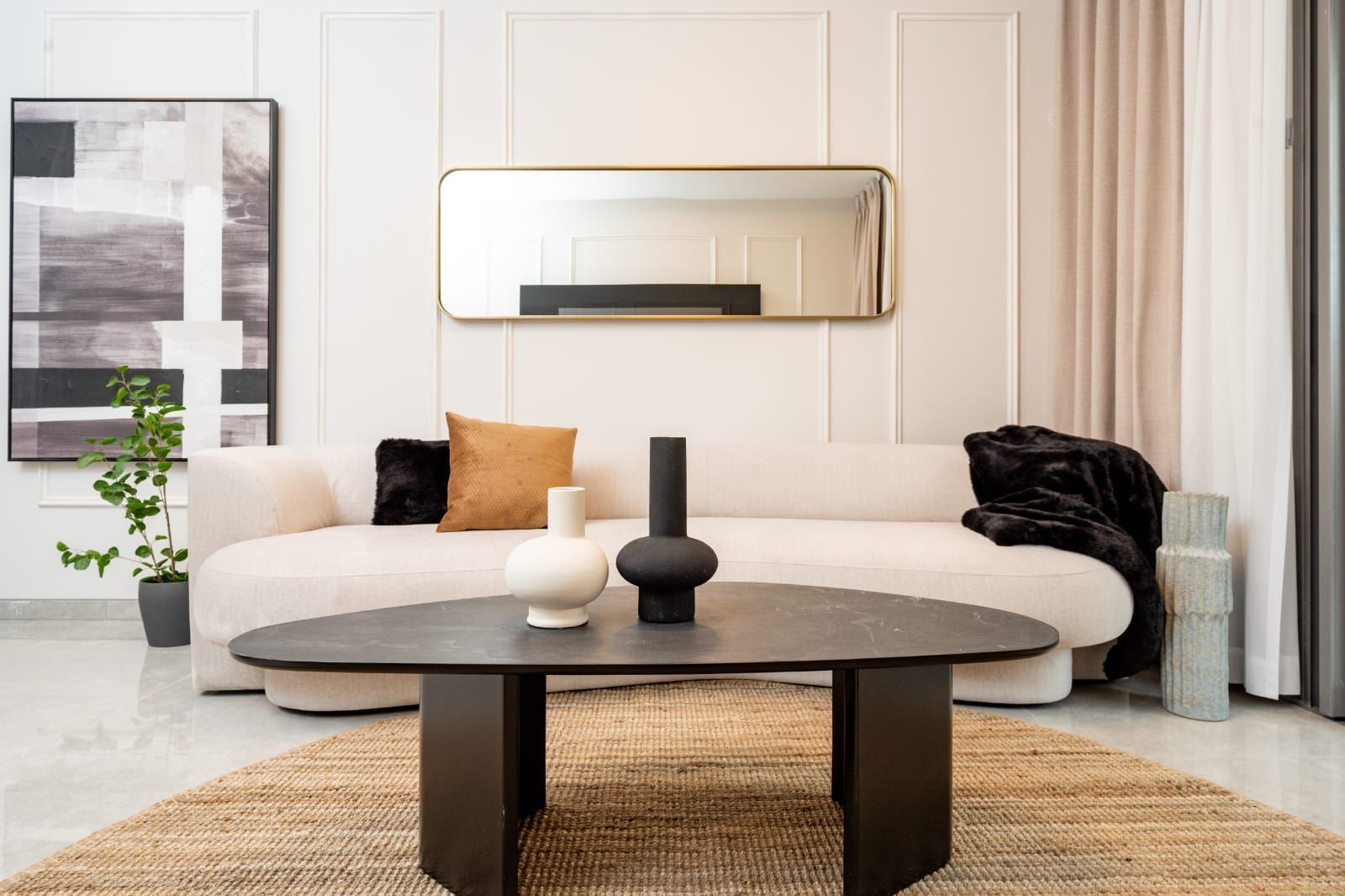 A living room with a couch , coffee table , and mirror. Kosher airbnb