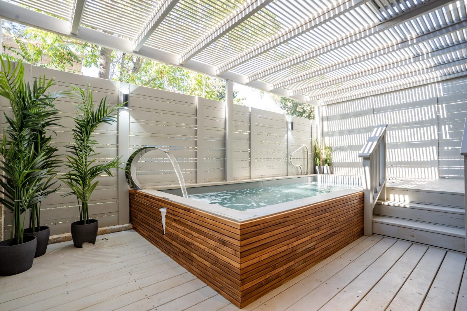 A wooden hot tub is sitting on top of a wooden deck.