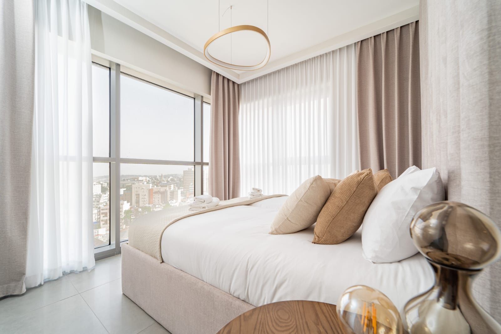 A bedroom with a king size bed and a large window.