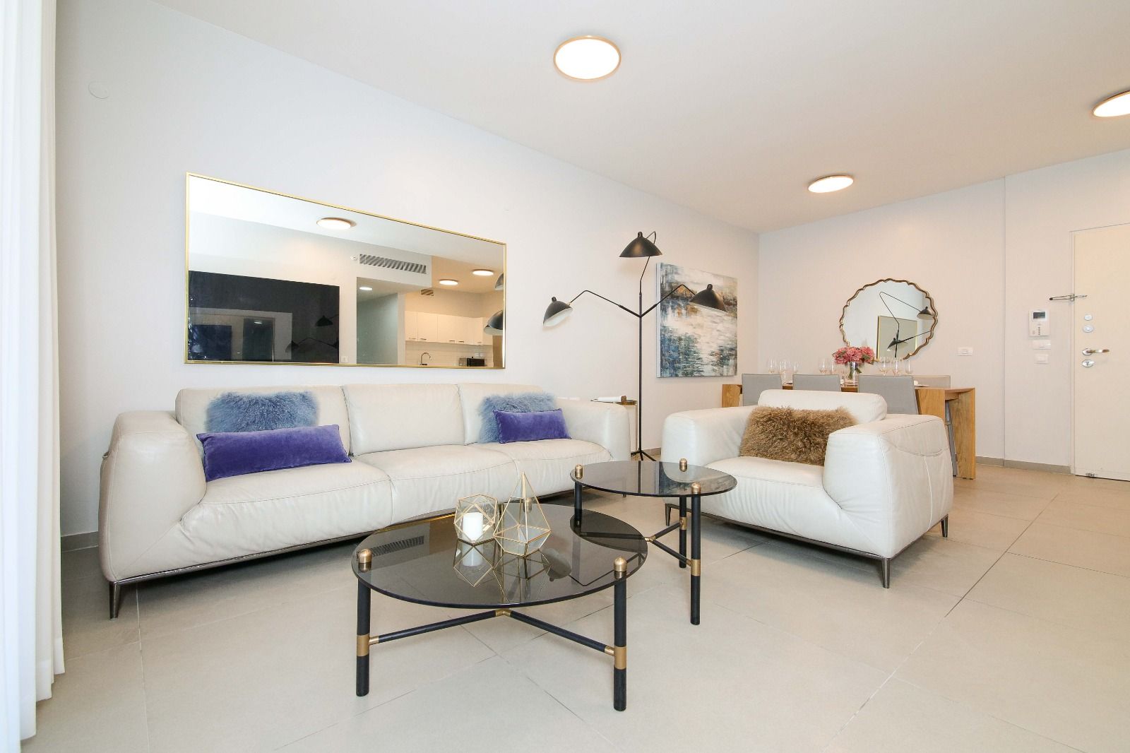 A living room with two white couches and a coffee table.