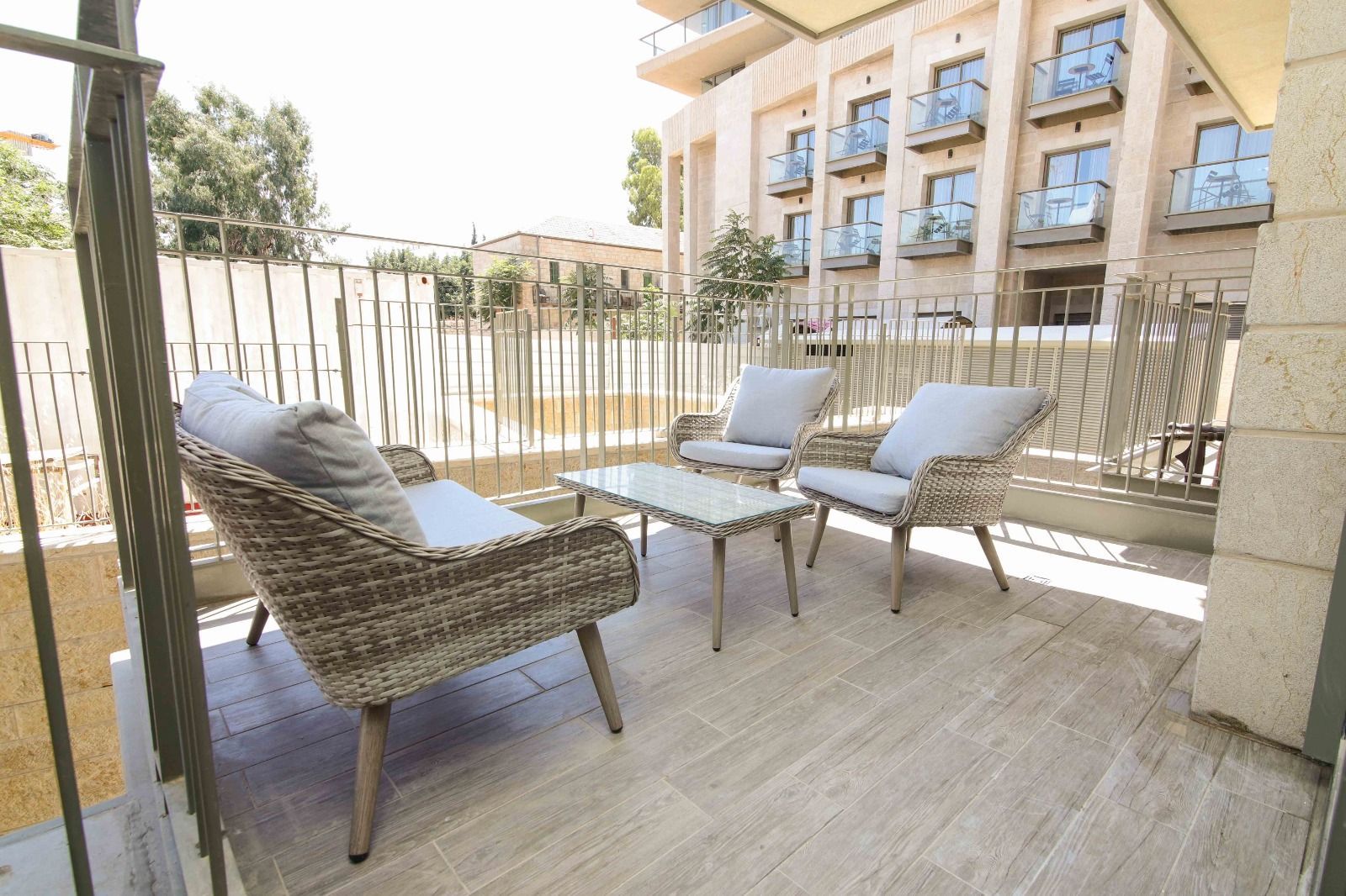 A balcony with wicker furniture and a table