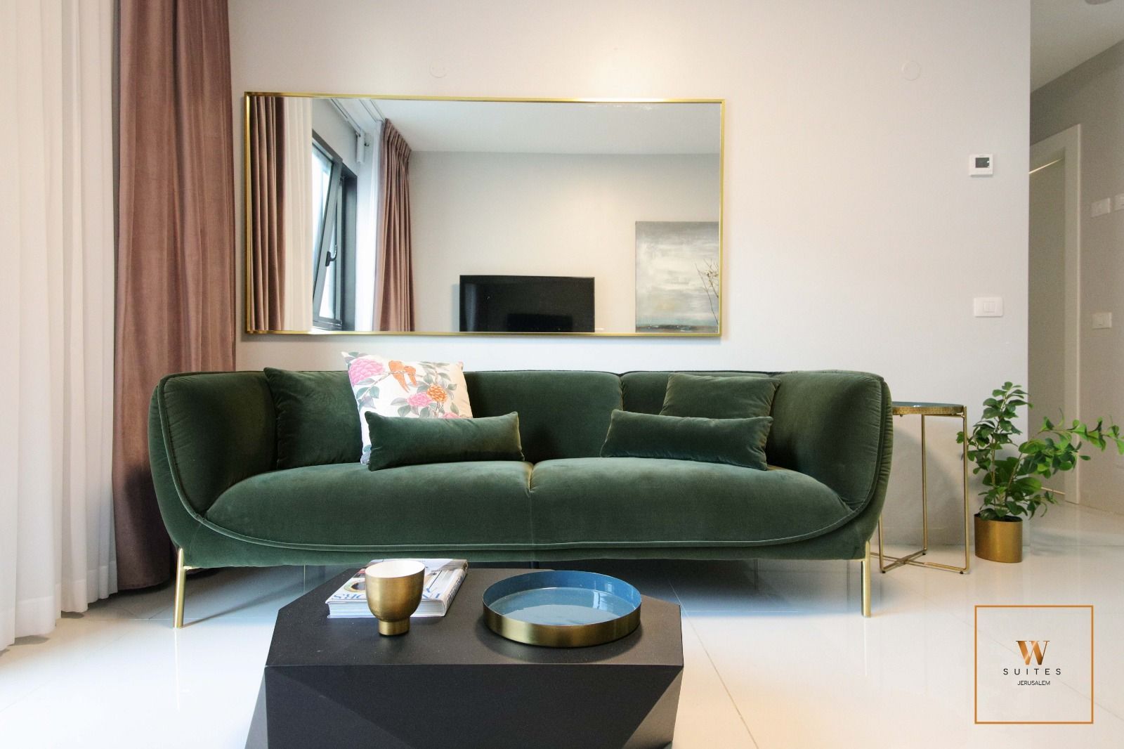 A living room with a green couch and a black coffee table.