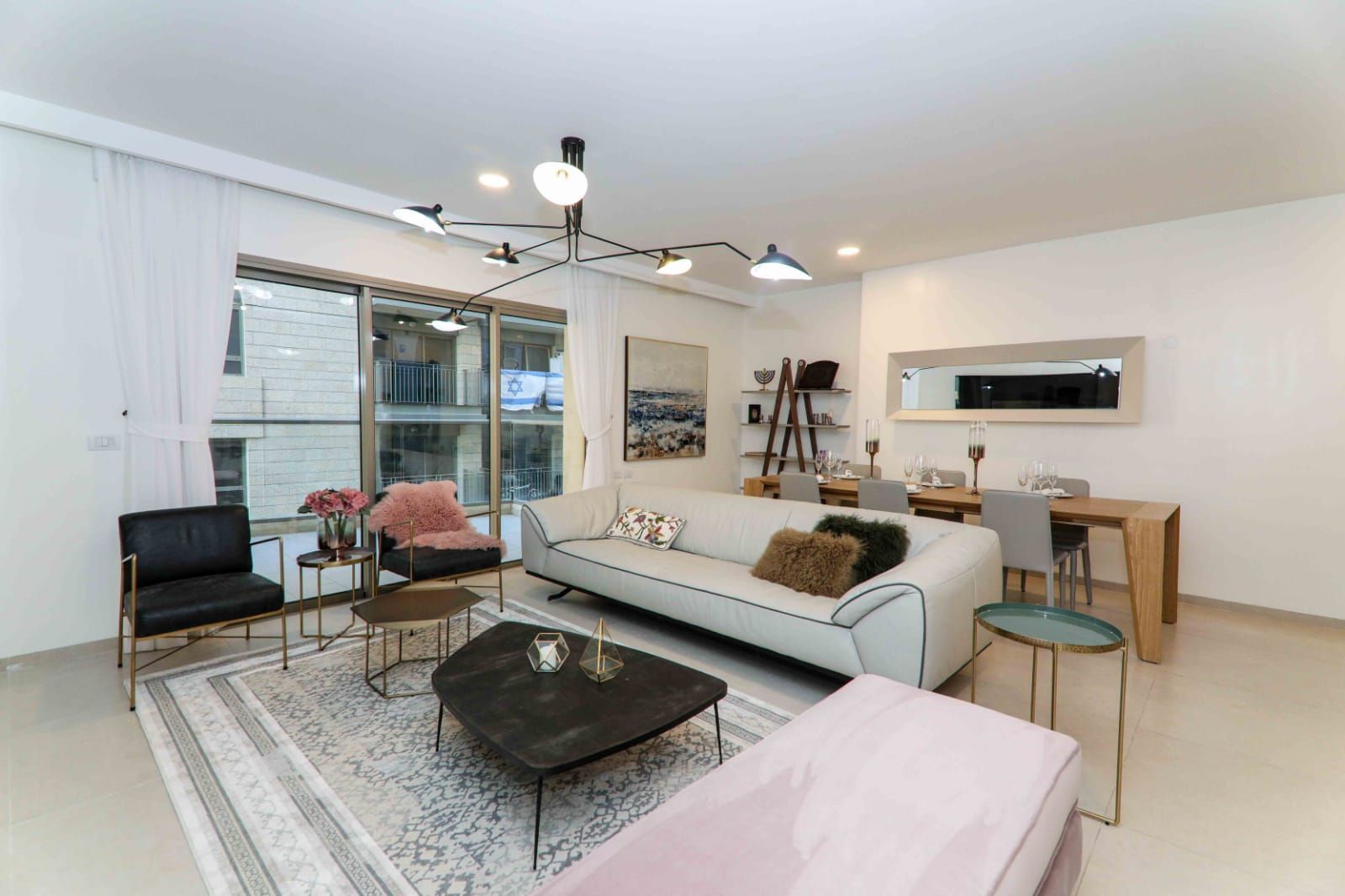 A living room with a couch , table , chairs and a rug.