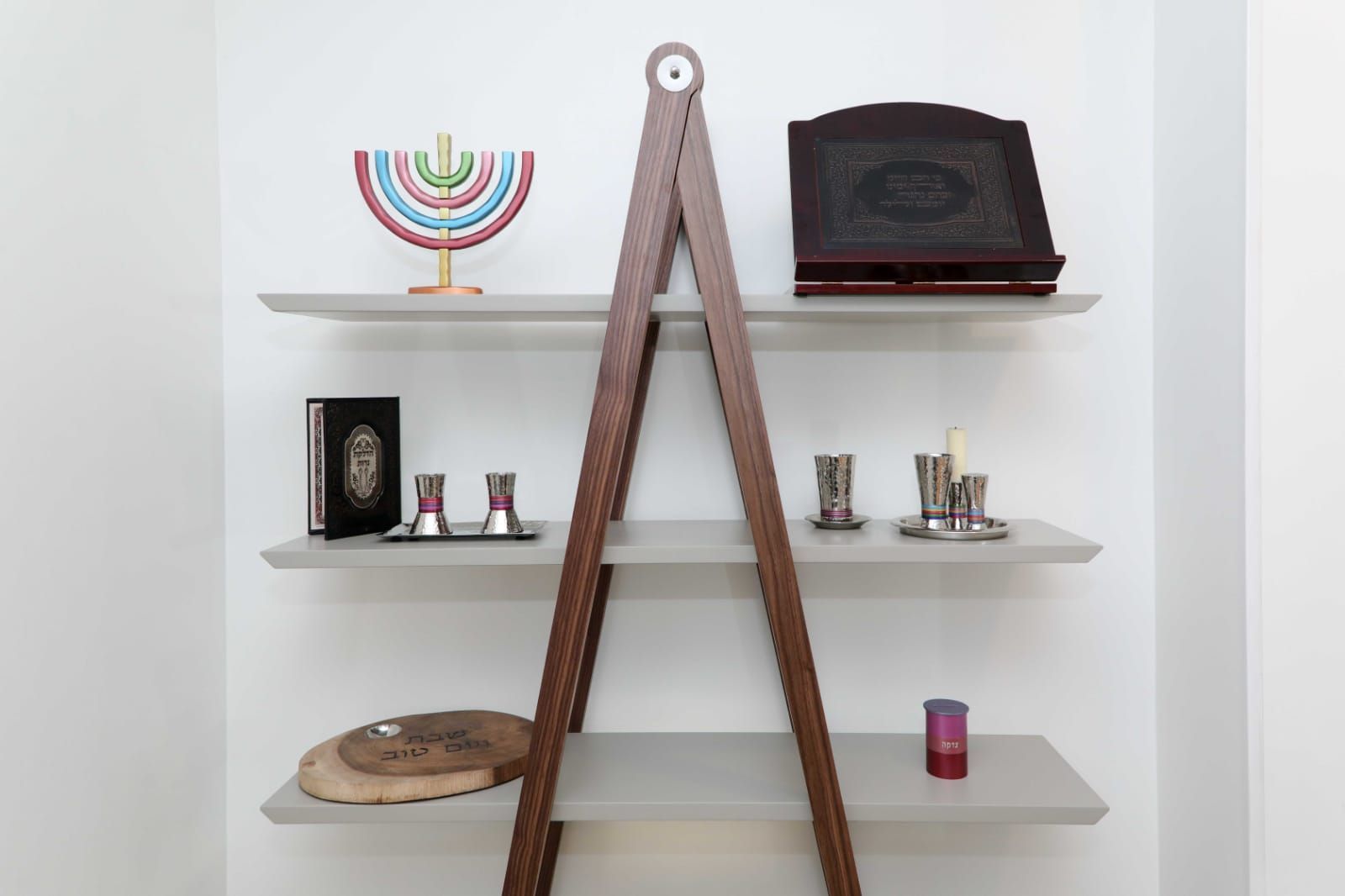 A shelf with a menorah and a book on it