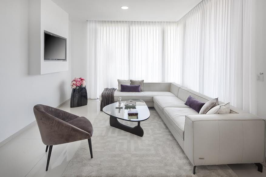 A living room with a couch , chair , coffee table and television.