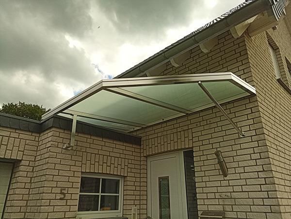 Ein Backsteingebäude mit einem Vordach über der Tür.