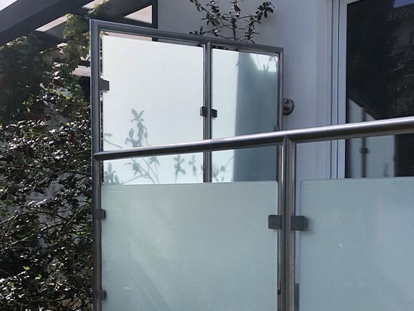 Ein Balkon mit Edelstahlgeländer und Milchglas