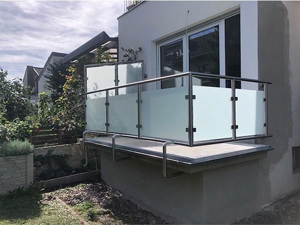 Ein Balkon mit Edelstahlgeländer und Milchglas.