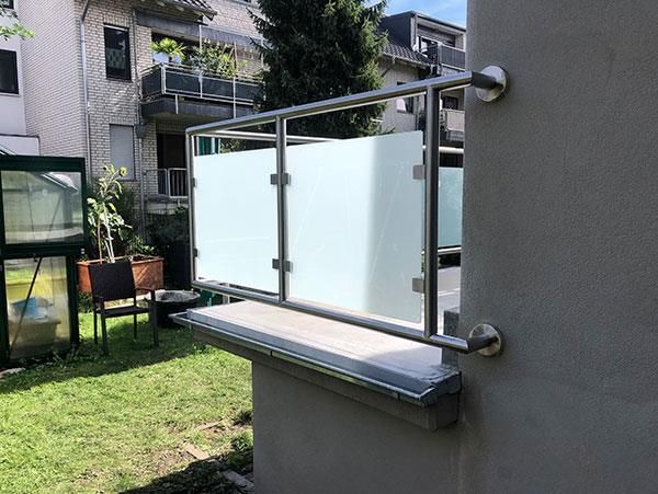 Ein Balkon mit Edelstahlgeländer und Milchglas.