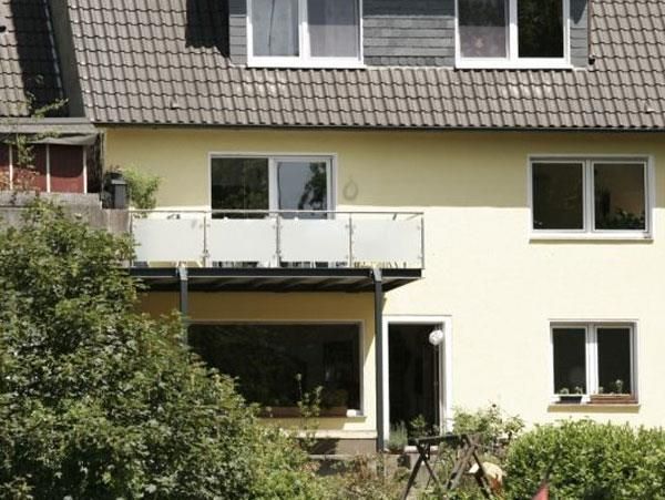 Ein gelbes Haus mit einem Balkon im zweiten Stock