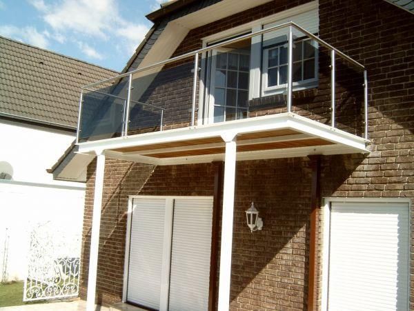 Ein Backsteinhaus mit Balkon im zweiten Stock