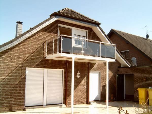 Ein Backsteinhaus mit Balkon im zweiten Stock