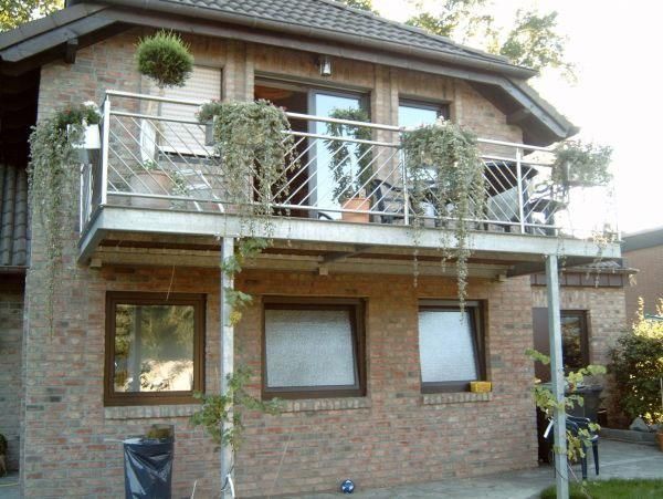 Ein Backsteinhaus mit Balkon im zweiten Stock