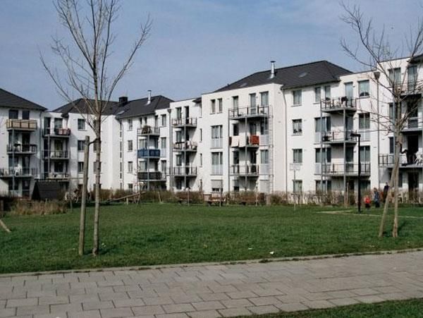 Eine Reihe von Wohnhäusern mit einer Wiese davor