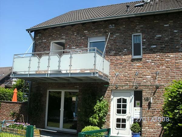 Ein Backsteinhaus mit einem Balkon und einer weißen Tür