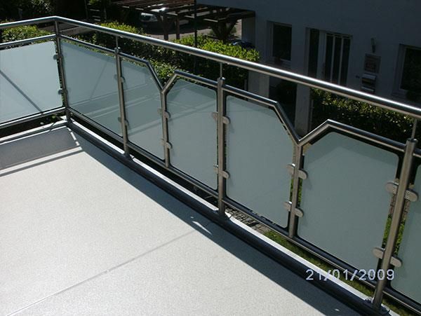 Ein Balkon mit Edelstahlgeländer und Milchglas