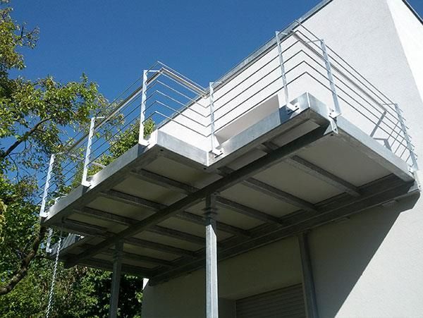 Ein Balkon mit einem Metallgeländer an der Seite eines Gebäudes