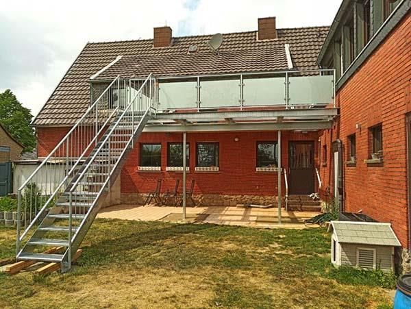 Ein Backsteingebäude mit einer Treppe, die zu einem Balkon führt.