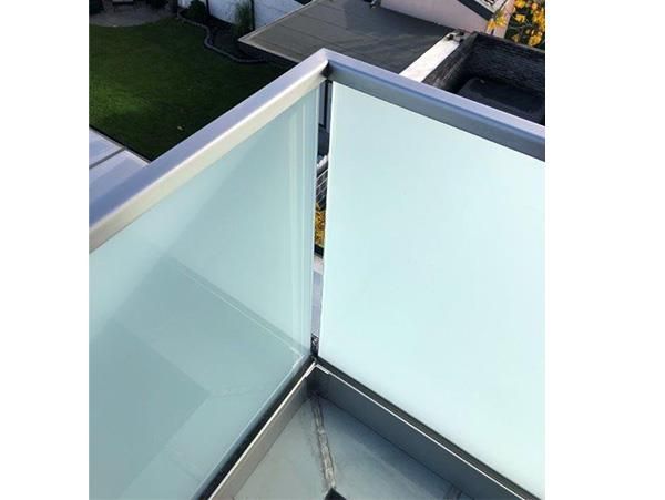 Ein Balkon mit Edelstahlgeländer und Milchglas.