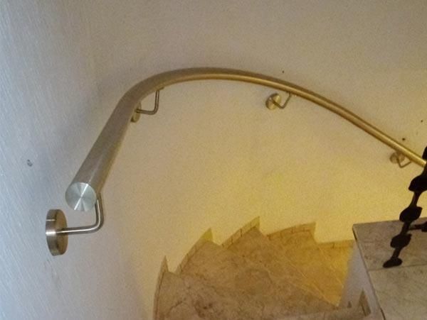 Eine Treppe mit einem Edelstahlgeländer an der Wand