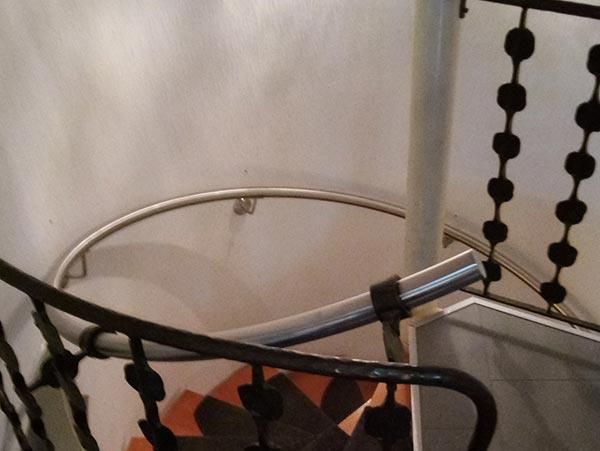 Eine Wendeltreppe mit schmiedeeisernem Geländer