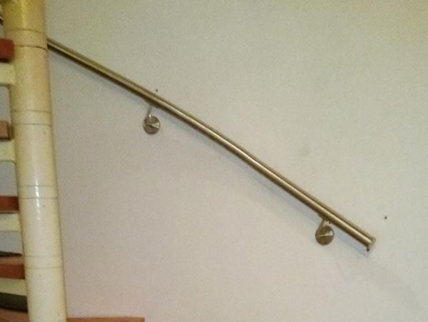 Eine Treppe mit einem Edelstahlhandlauf an der Wand