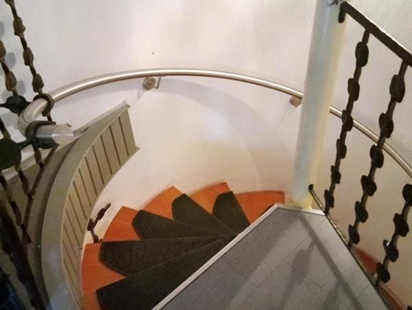 Eine Wendeltreppe mit einem Sichtschutz auf der untersten Stufe