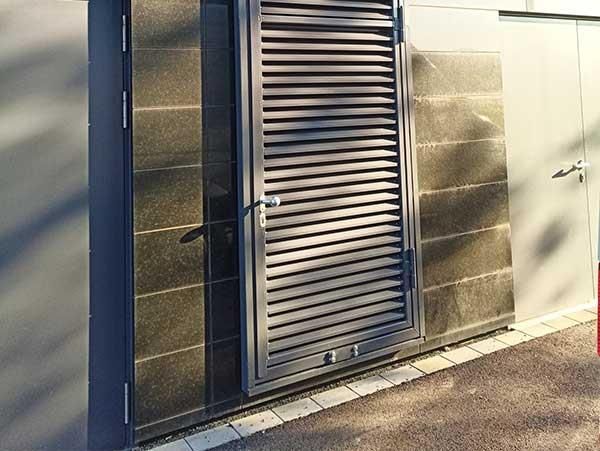 An der Seite eines Gebäudes befindet sich eine Tür mit Fensterläden.