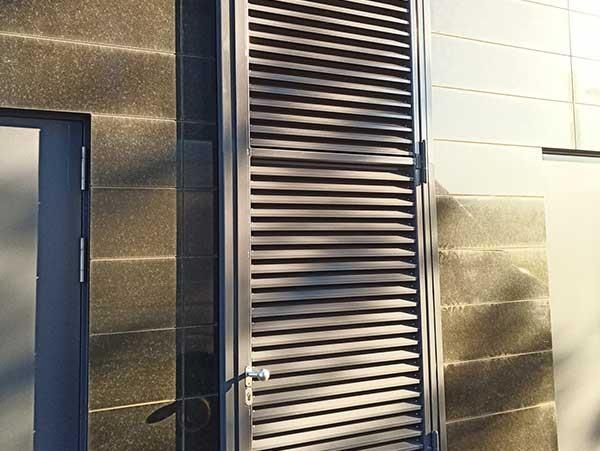 An der Seite eines Gebäudes befindet sich eine Tür mit Fensterläden.