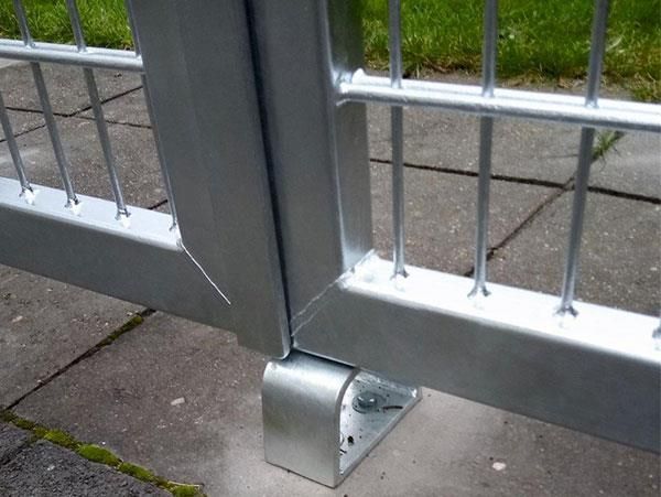 Eine Nahaufnahme eines Metallzauns auf einem Gehweg.