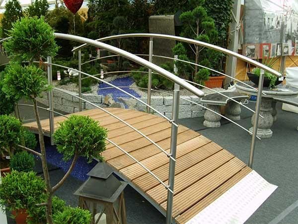 Eine Holzbrücke mit einem Edelstahlgeländer