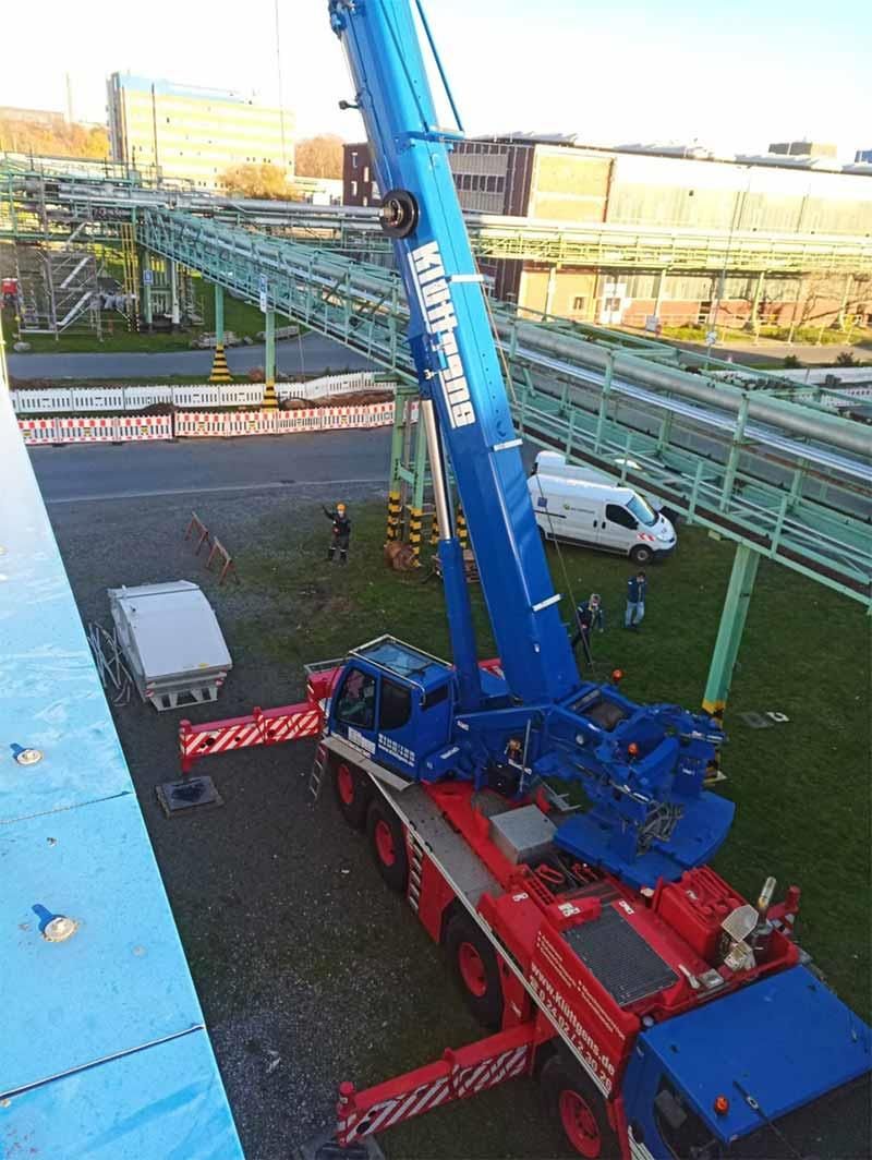 Auf einem Parkplatz steht ein großer Kran auf einem LKW.