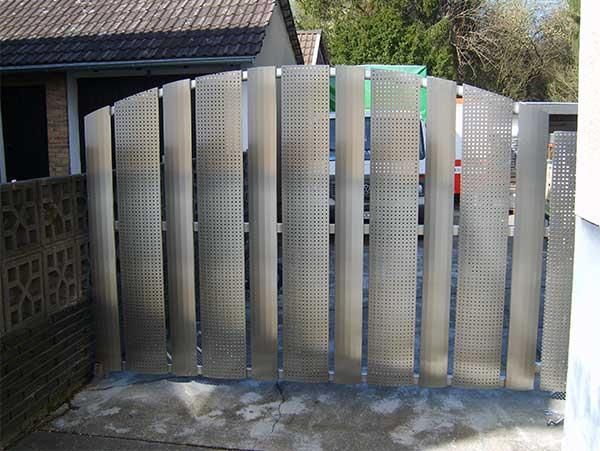 Vor einem Haus steht ein Edelstahltor.