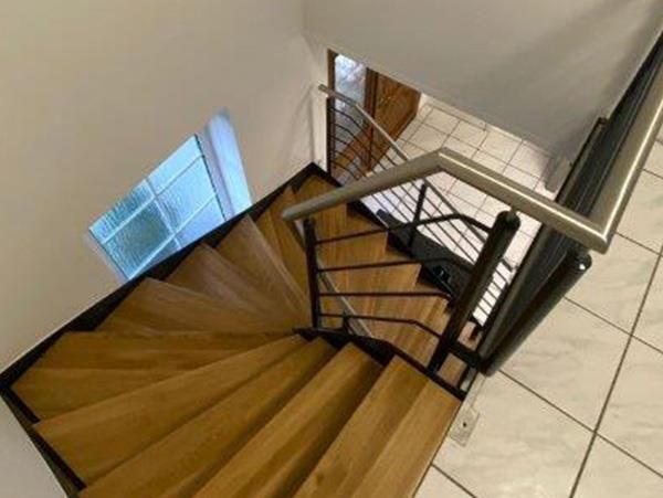 Eine Wendeltreppe mit Holzstufen und einem Metallgeländer
