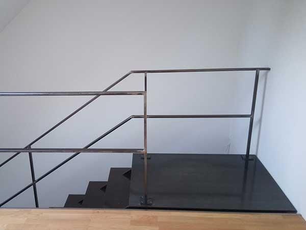 Eine Treppe mit Metallgeländer und Holzboden