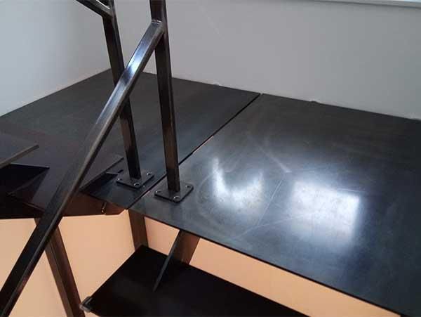 Eine schwarze Treppe mit einem Metallgeländer und Stufen