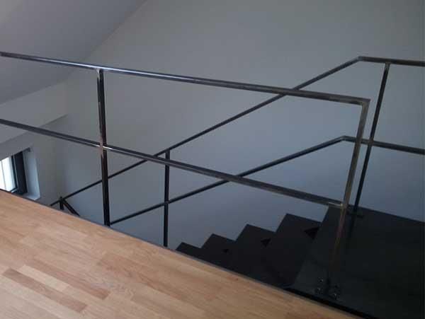 Eine Treppe mit Metallgeländer und Holzboden