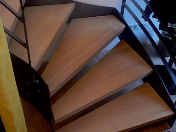 Eine Wendeltreppe mit Holzstufen und einem Metallgeländer