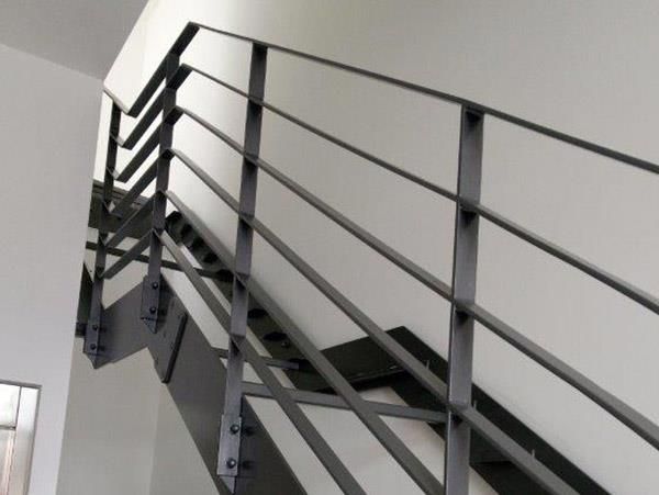 Eine Treppe mit einem Metallgeländer vor einer weißen Wand