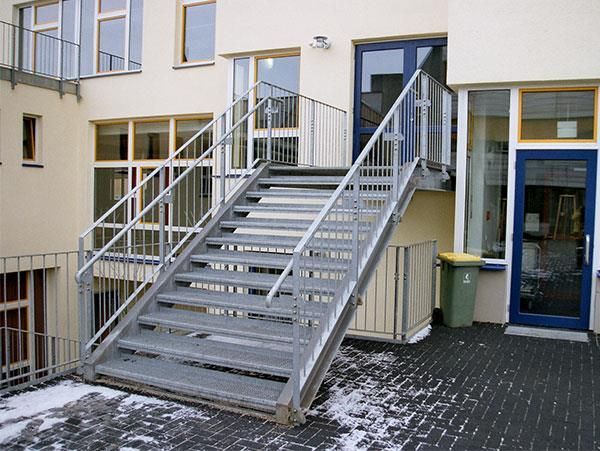 Eine Treppe, die zu einem Gebäude mit einer blauen Tür führt