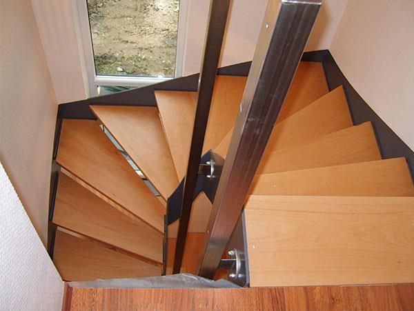 Eine Wendeltreppe mit Holzstufen und einem Metallgeländer