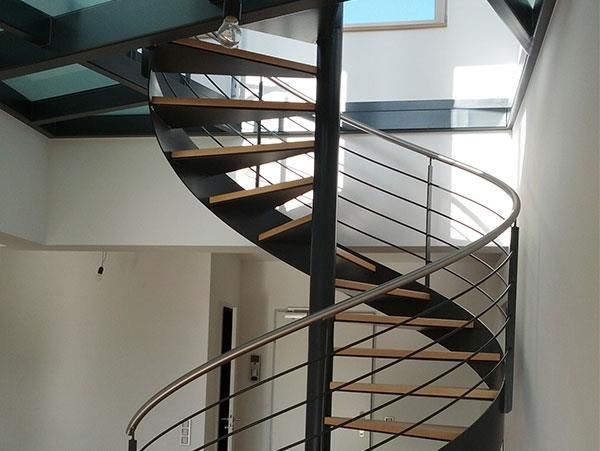 Eine Wendeltreppe mit Holzstufen und einem Metallgeländer