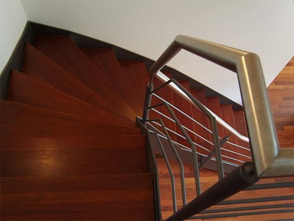 Eine hölzerne Wendeltreppe mit einem Metallgeländer